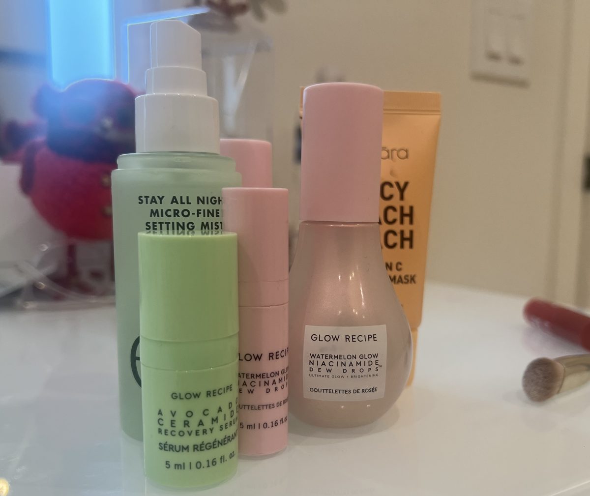 TikTok viral skincare and makeup with heavy fragrances, including E.L.F. Stay All Night Setting Mist, three sizes of Glow Recipe Watermelon Glow Niacinamide Dew Drops, and Glow Recipe Avocado Ceramide Recovery Serum.