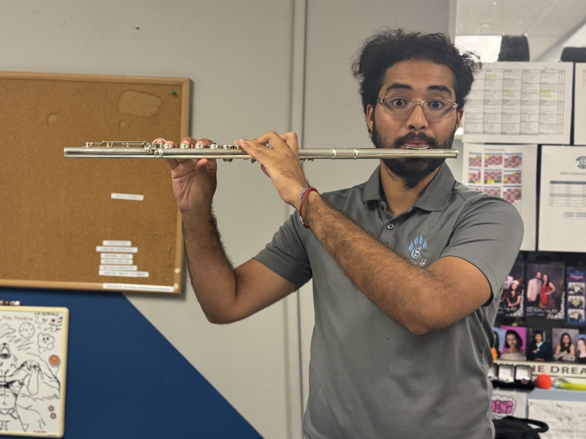 New band teacher Brandon Arguello playing the flute.