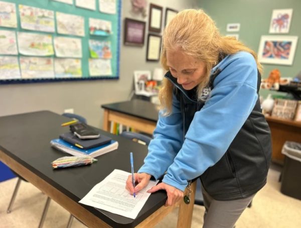 AICE Marine Science teacher Mrs. Grassi signing an exemption form for one of her students.