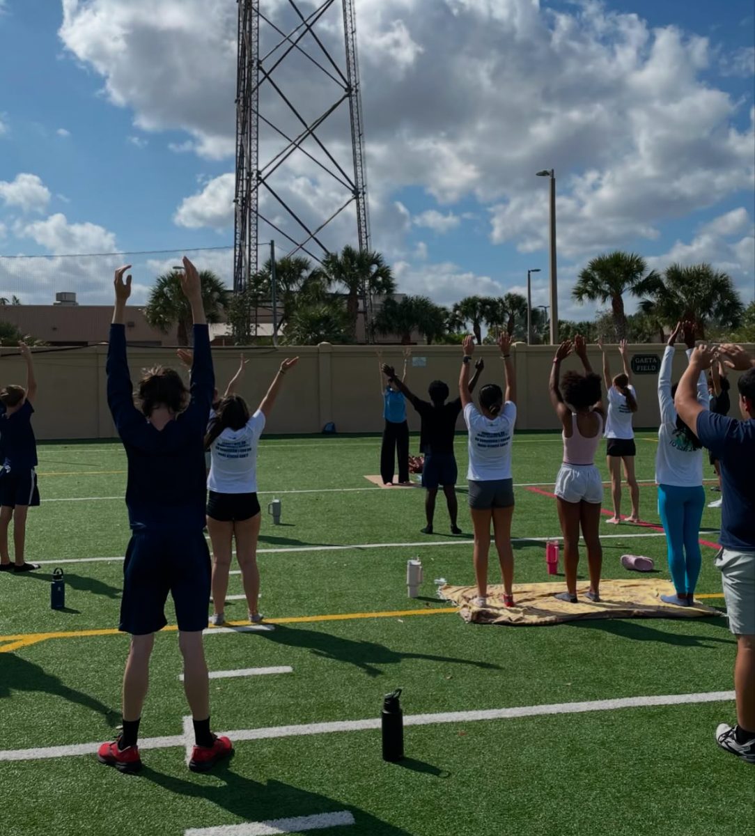 Track athletes stretching on the field, getting ready to run.