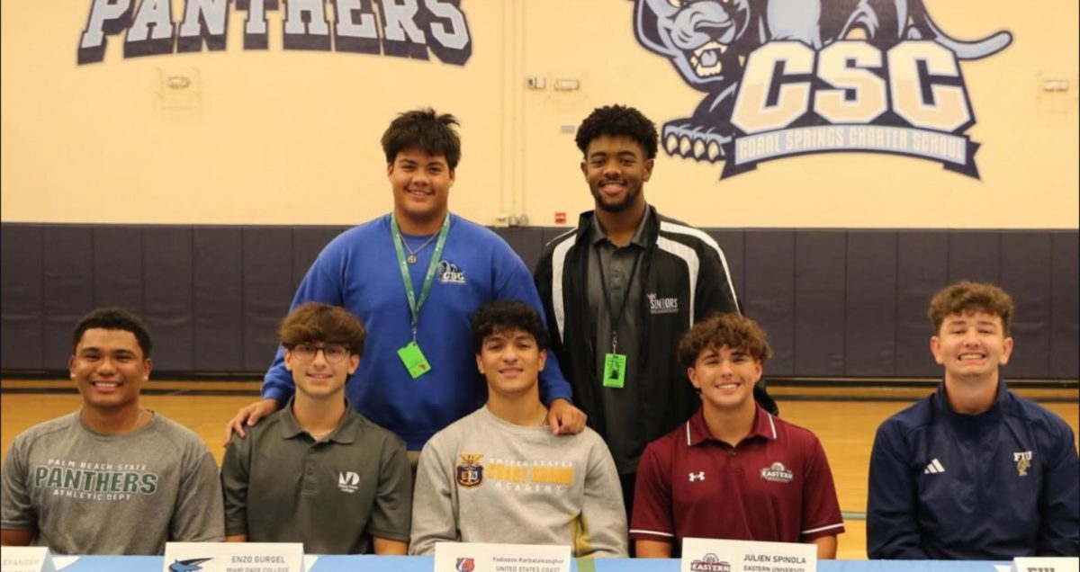 Senior baseball team signing, and teammates supporting their peers.