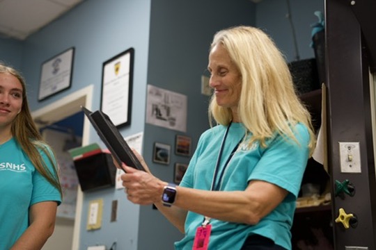 Marine Science teacher Kristin Grassi inspects a bulletproof insert as shown by a guest speaker.