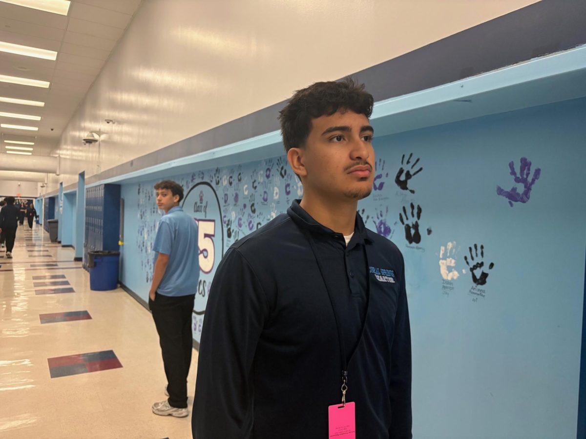Junior Marlon Certuche walking the hallways while Junior Bryan Kiley looks back at him.