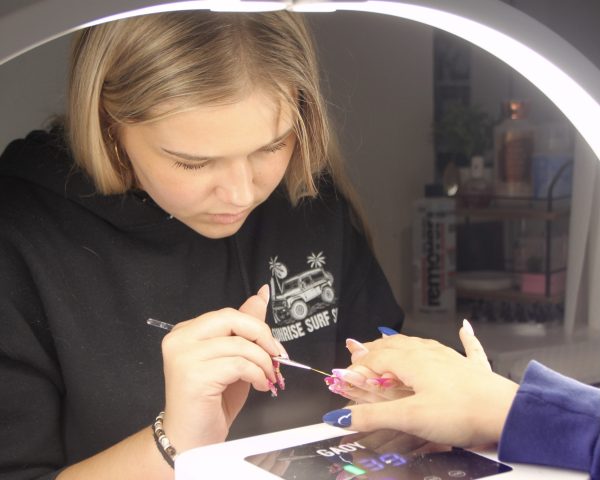 Senior Colbie Harootunian doing a clients nails after school in her room.